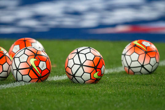 Bollar ligger på gräset före fotbollsmatchen och kval