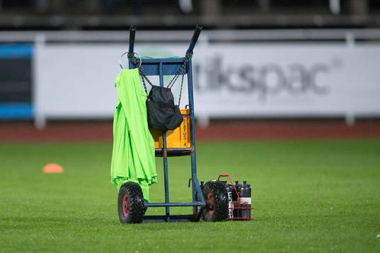 En dryckesvagn står på gräset före fotbollsmatchen och