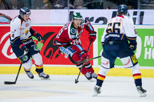 Frölundas Johan Sundström med pucken mellan Djurgårdens
