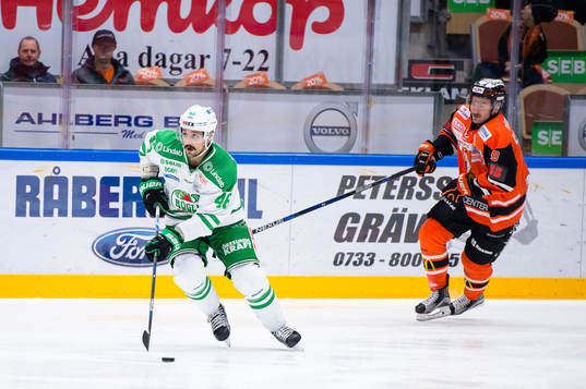 Rögles Kevin Marshall med pucken jagas av Karlskronas