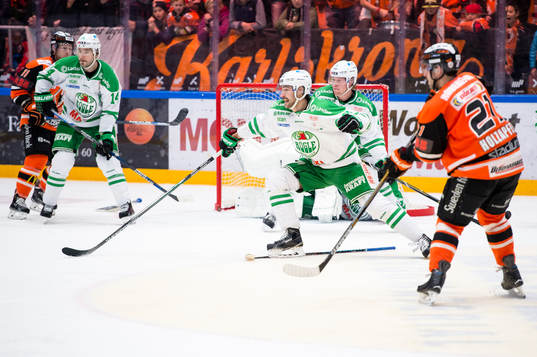 Rögles Jack Connolly försöker slå undan pucken