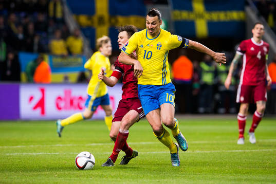 Danmarks William Kvist i kamp om bollen med Sveriges Zlatan