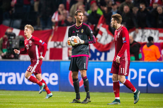 Sveriges målvakt Andreas Isaksson mellan Danmarks Viktor