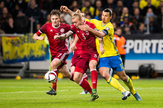 Danmarks Simon Kjär i kamp om bollen med Sveriges Zlatan