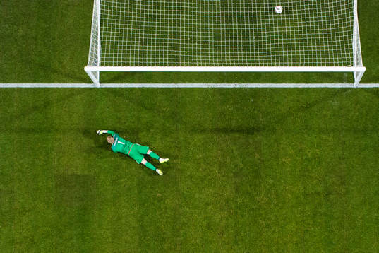 Danmarks målvakt Kasper Schmeichel ligger kvar i gräset