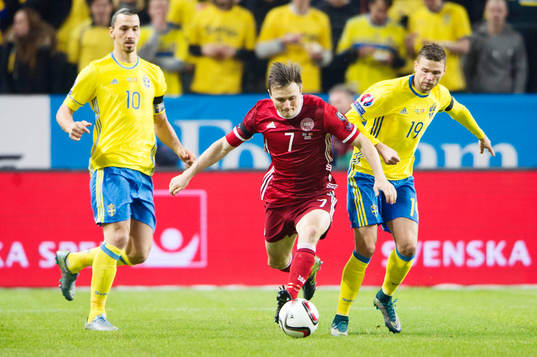 Danmarks William Kvist i kamp om bollen med Sveriges Marcus