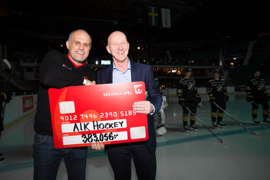Gräsroten och Svenska Spels Pierre Jonsson delar ut en