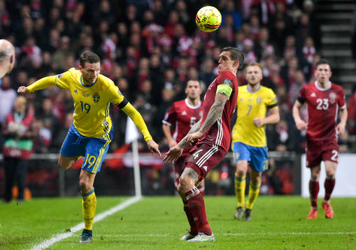 Sveriges Marcus Berg klackar bollen framför Danmarks