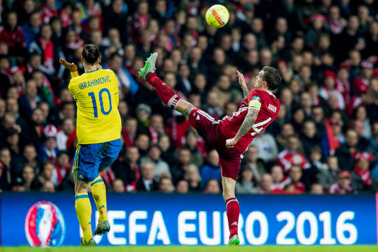 Danmarks Daniel Agger rensar undan framför Sveriges Zlatan