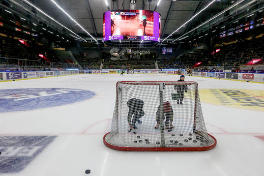 Pojkar som plockar puckar från isen