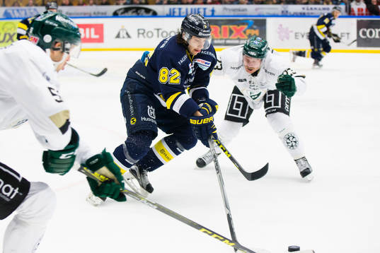 s Kevin Stenlund med pucken mot Färjestads Martin Röymark
