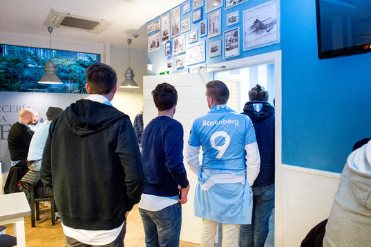 En supporter i Rosenberg tröja köar till toaletterna på