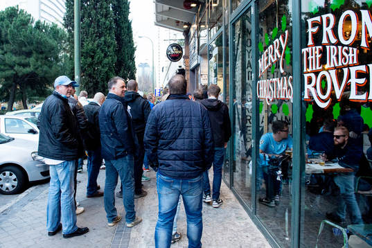 Supportrar köar för att komma in till en bar på Avenida