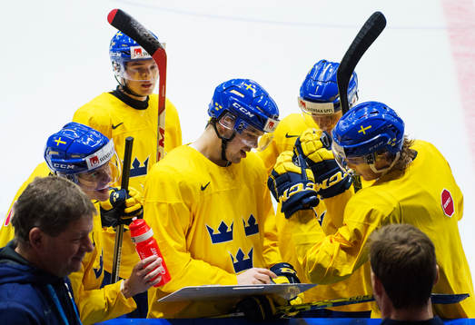 Axel Holmström (mitten) ritar på en taktiktavla