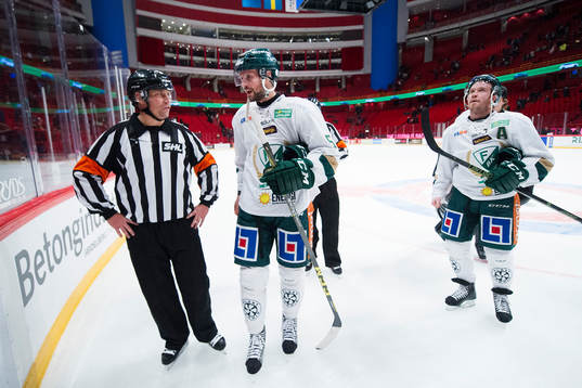 Domare Sören Persson diskuterar med Färjestads Rickard
