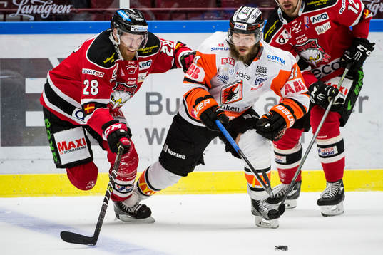 Malmö Redhawks Jens Olsson i kamp om pucken mot