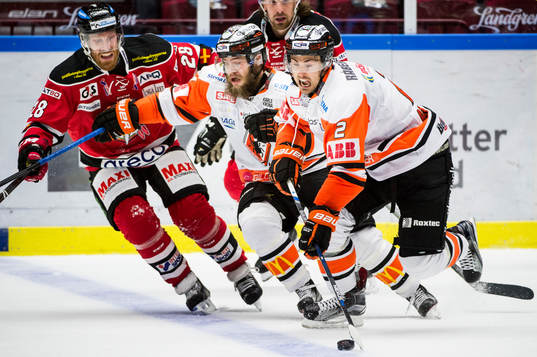 Malmö Redhawks Jens Olsson i kamp om pucken mot