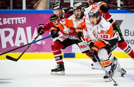 Malmö Redhawks Jens Olsson i kamp om pucken mot