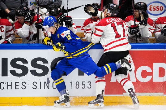 Sveriges Rasmus Asplund blir tacklad av Kanadas Travis