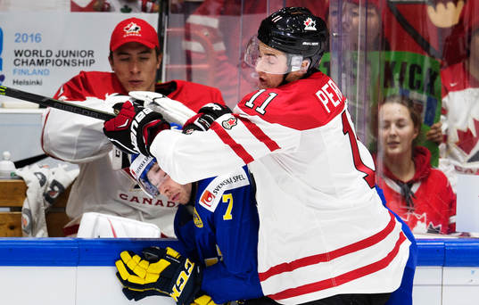 Sveriges Marcus Pettersson blir tacklad av Kanadas Brendan