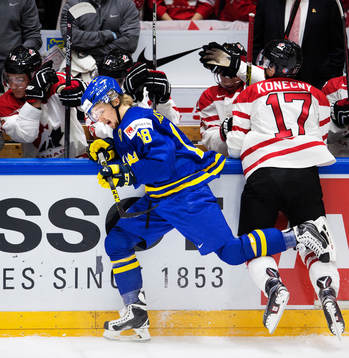 Sveriges Rasmus Asplund blir tacklad av Kanadas Travis