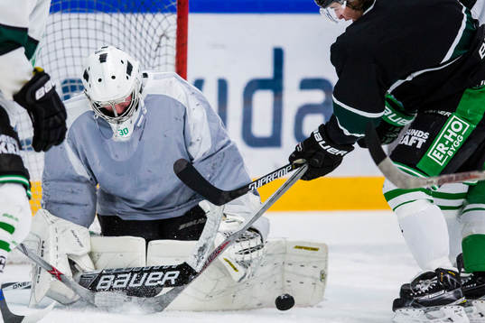 Rögles målvakt Victor Carlsson täcker en puck