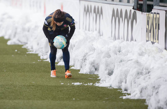 Rosengårds Ali Riley hämtar bollen i snödrivorna