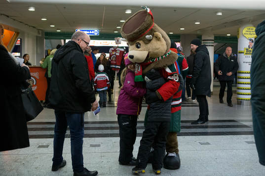 Frölundas maskot kramar två unga supportrar