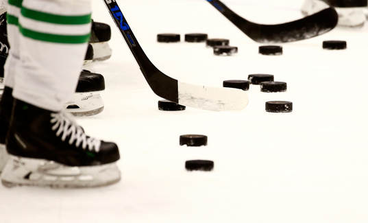 En generell bild av klubba, skridskor och ishockeypuckar