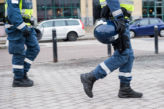 ordningsvakter utrustade med hjälmp utanför arenan