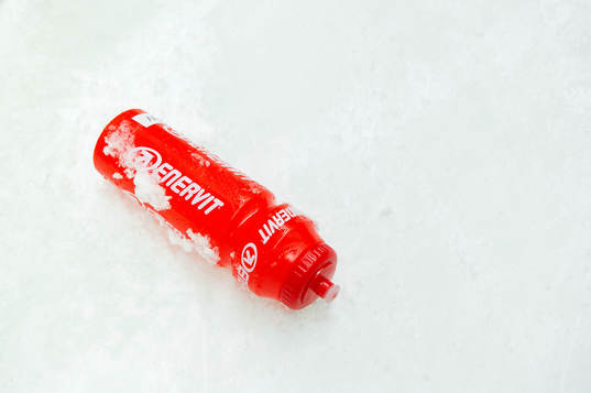 En Enervit vattenflaska ligger på isen