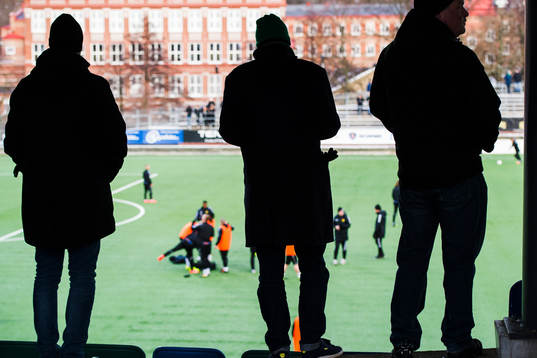 tre supportrar tittar på uppvärmningen