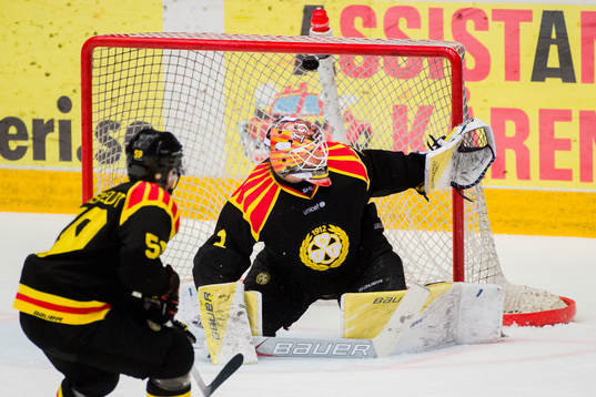 Pucken passerar ovanför Brynäs målvakt Felix Sandström