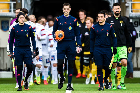 Domarna och spelarna går in på planen före  en