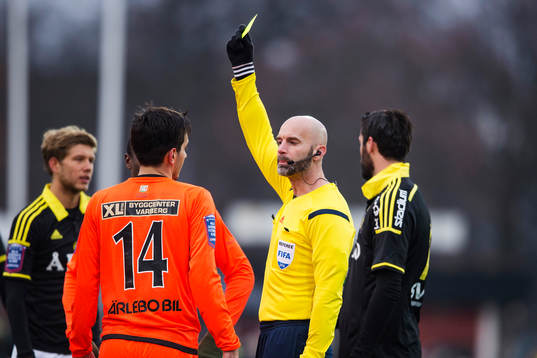 Domare Stefan Johannesson delar ut ett gult kort till