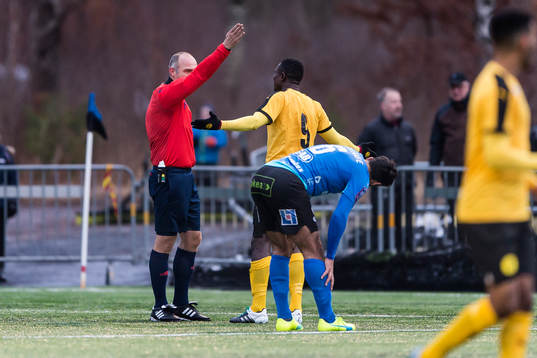 Domare Robert Daradic ger gult kort till Frejs Oke Akpoveta