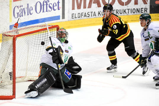 Färjestads målvakt Justin Pogge får hjälp av ribban