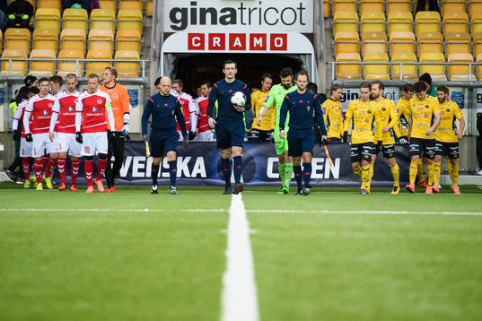Domare och spelare kommer in till match