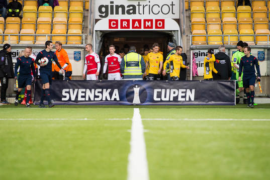 Domare och spelare kommer in på planen innan en