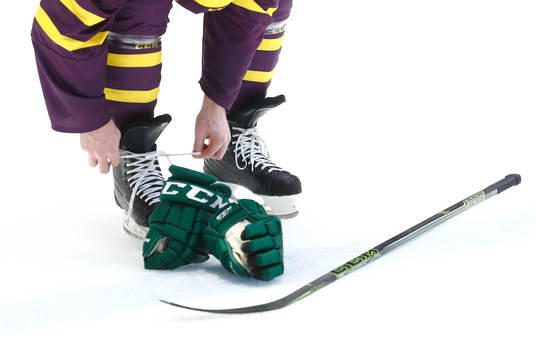 Generell bild av en ishockeyspelare som knyter skridskor