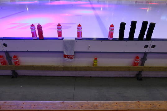 Bortalagets spelarbås med puckarna till uppvärmningen