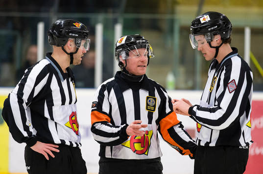 Domare Peter Lyth pratar med linjemännen Andreas Lundén