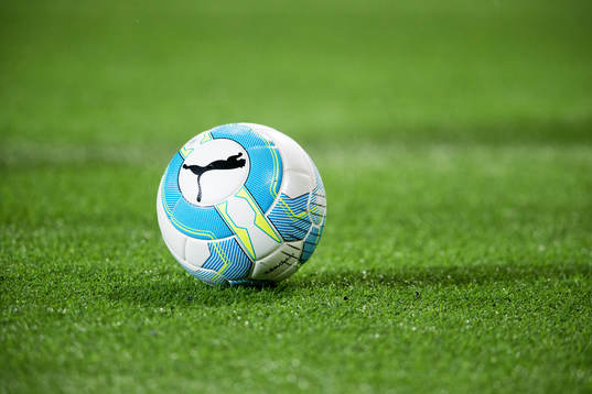 En fotboll ligger på konstgräset