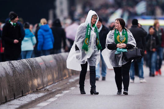 Två supportrar i regnjackor