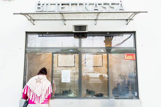 En kvinna besöker biljettkassan