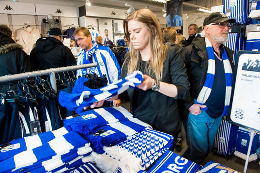 En funktionär organiserar halsdukar i shopen