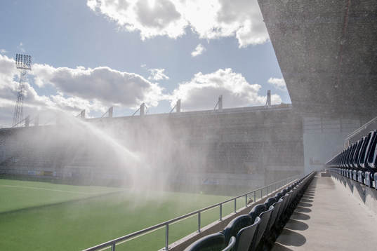 Vattenspridaren på planen före fotbollsmatchen i