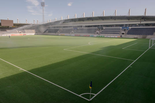 Vattenspridaren på planen före fotbollsmatchen i
