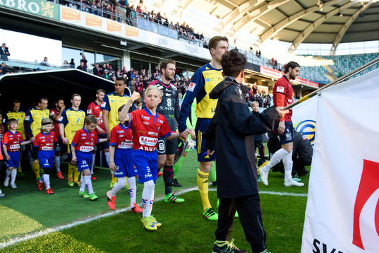 Spelarna går in på planen innan fotbollsmatchen i