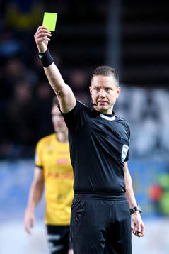 Domare Martin Strömbergsson visar ett gult kort